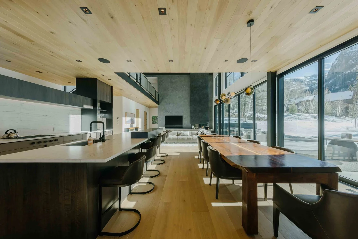 Una amplia cocina y comedor con una encimera larga y grandes ventanas.