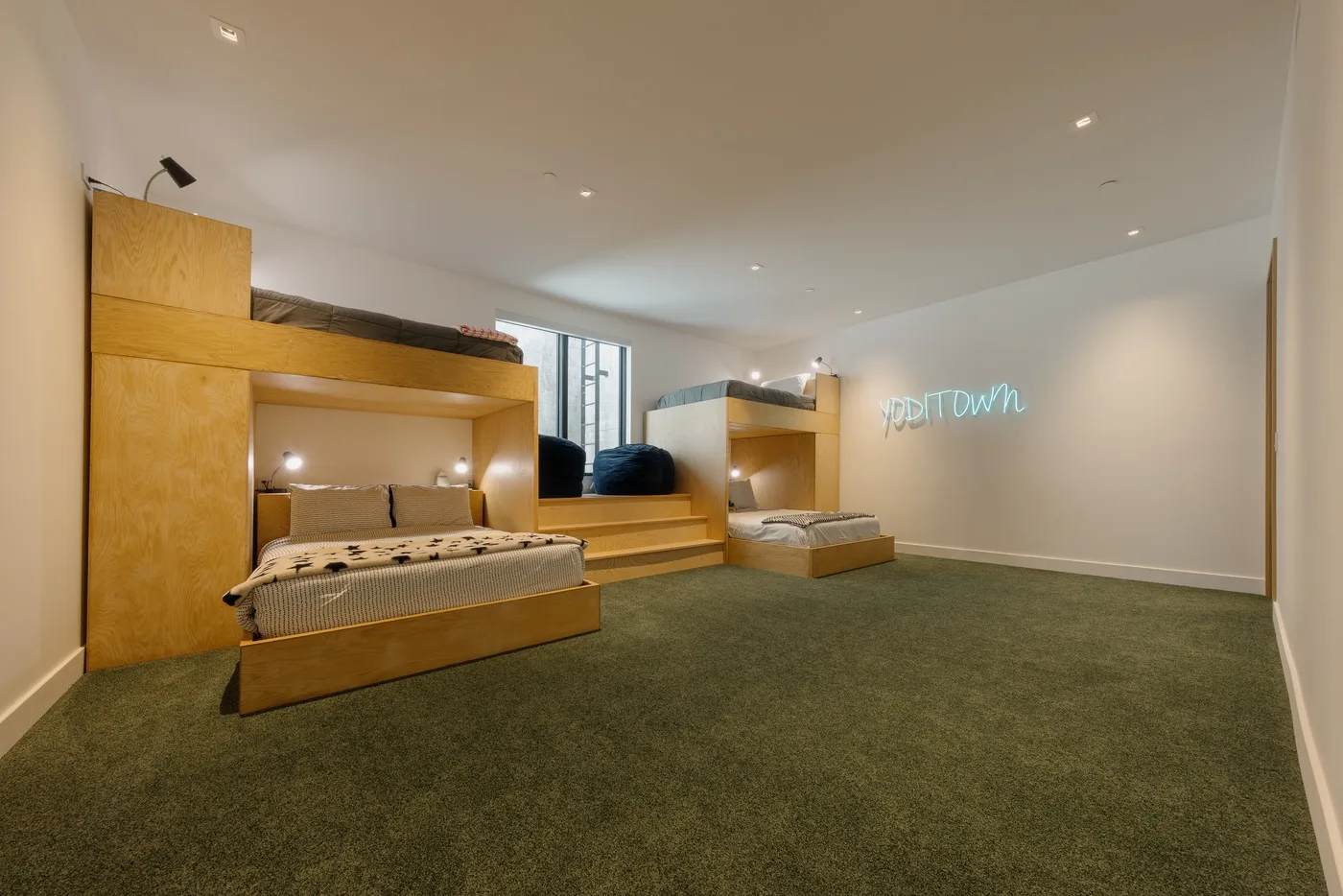 Un dormitorio con plataformas elevadas para dormir y suelo alfombrado.