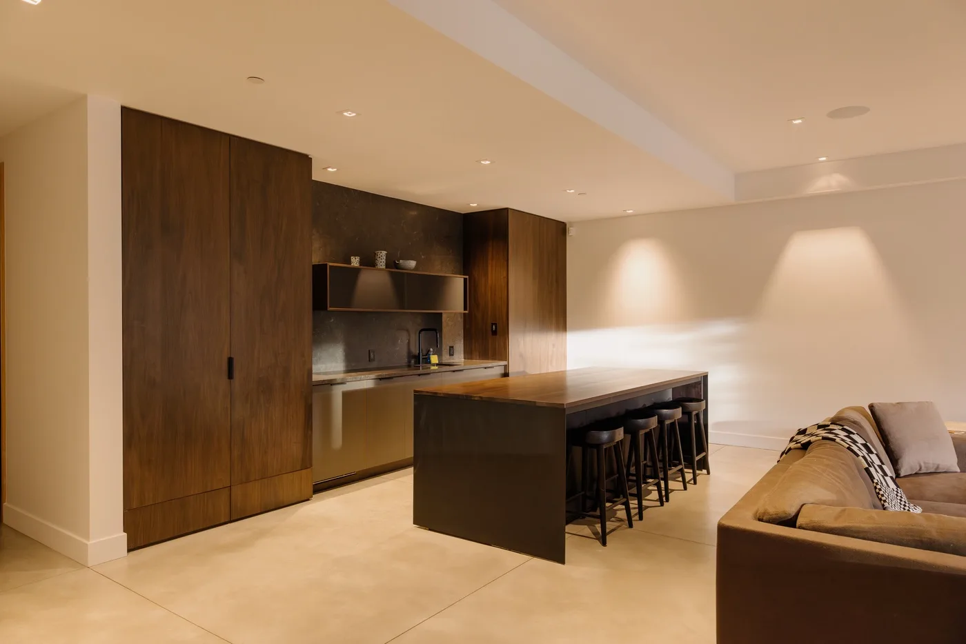 Una cocina moderna con una isla central y una zona de estar contigua.