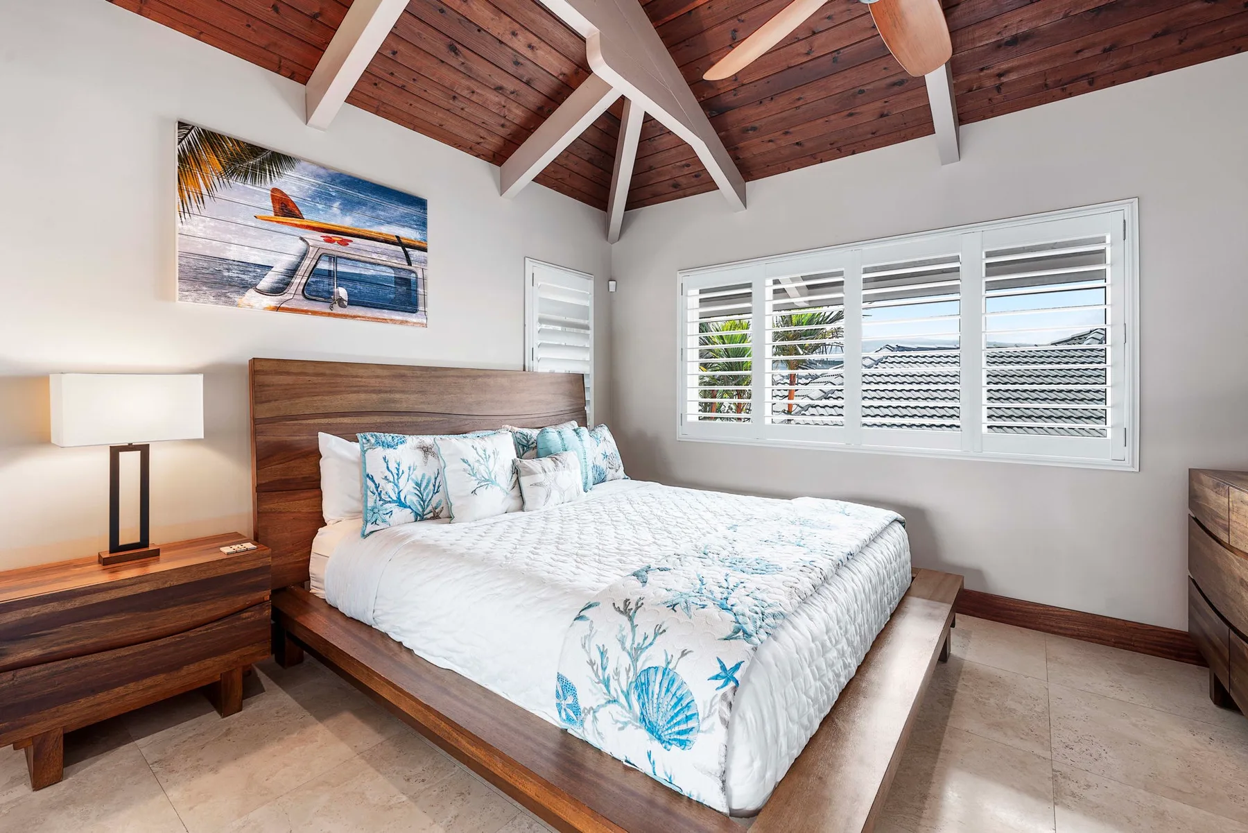 Un dormitorio con una cama de madera, ropa de cama blanca y ventanas con persianas.