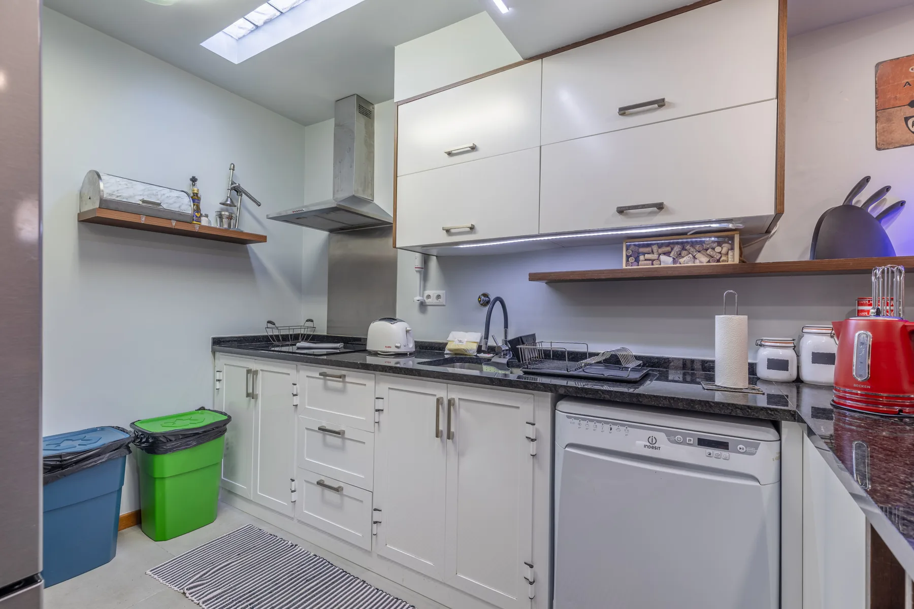 A bright kitchen with white cabinets and a countertop.