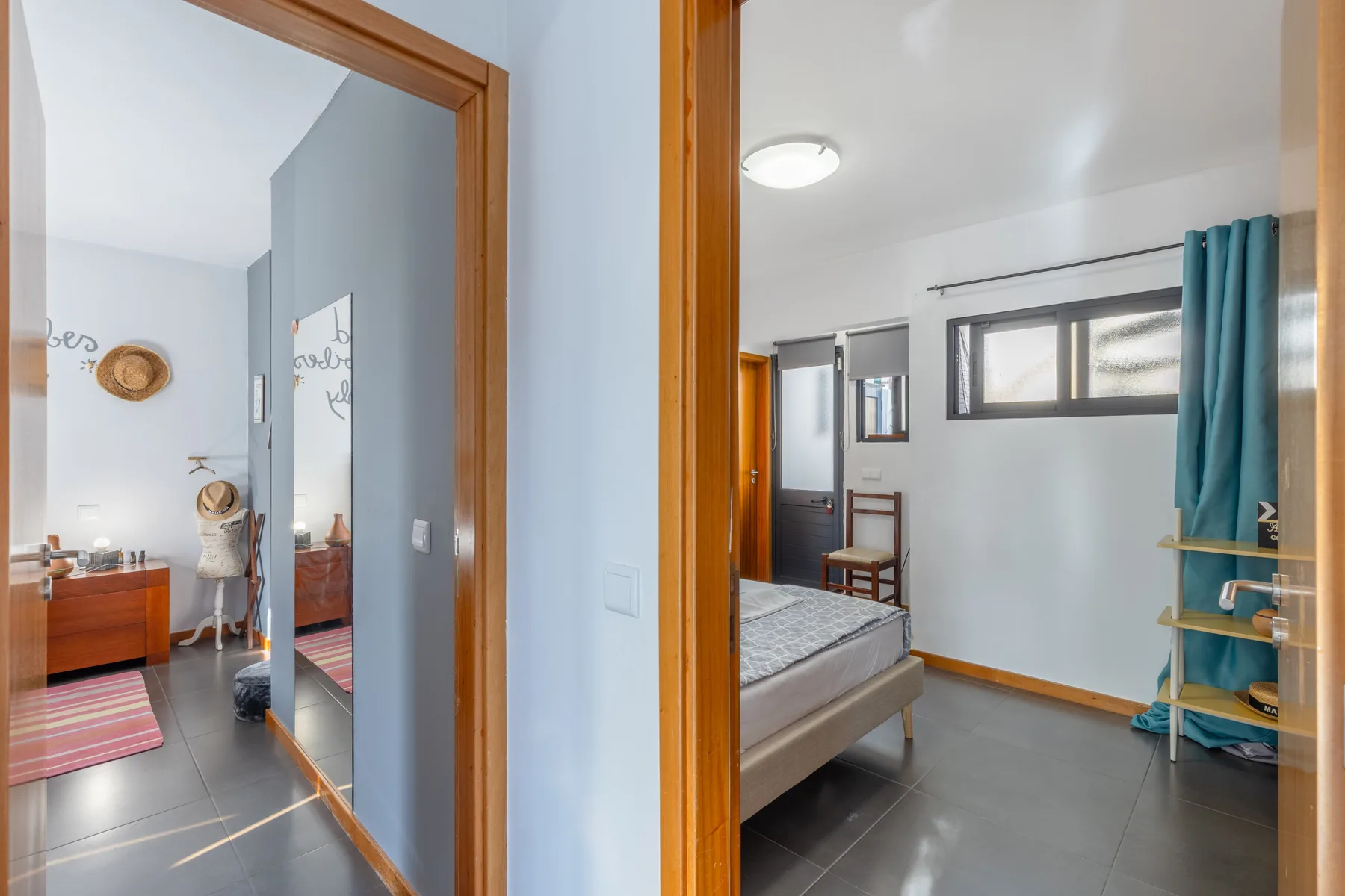 A bedroom is visible through a doorway beside a bathroom vanity.