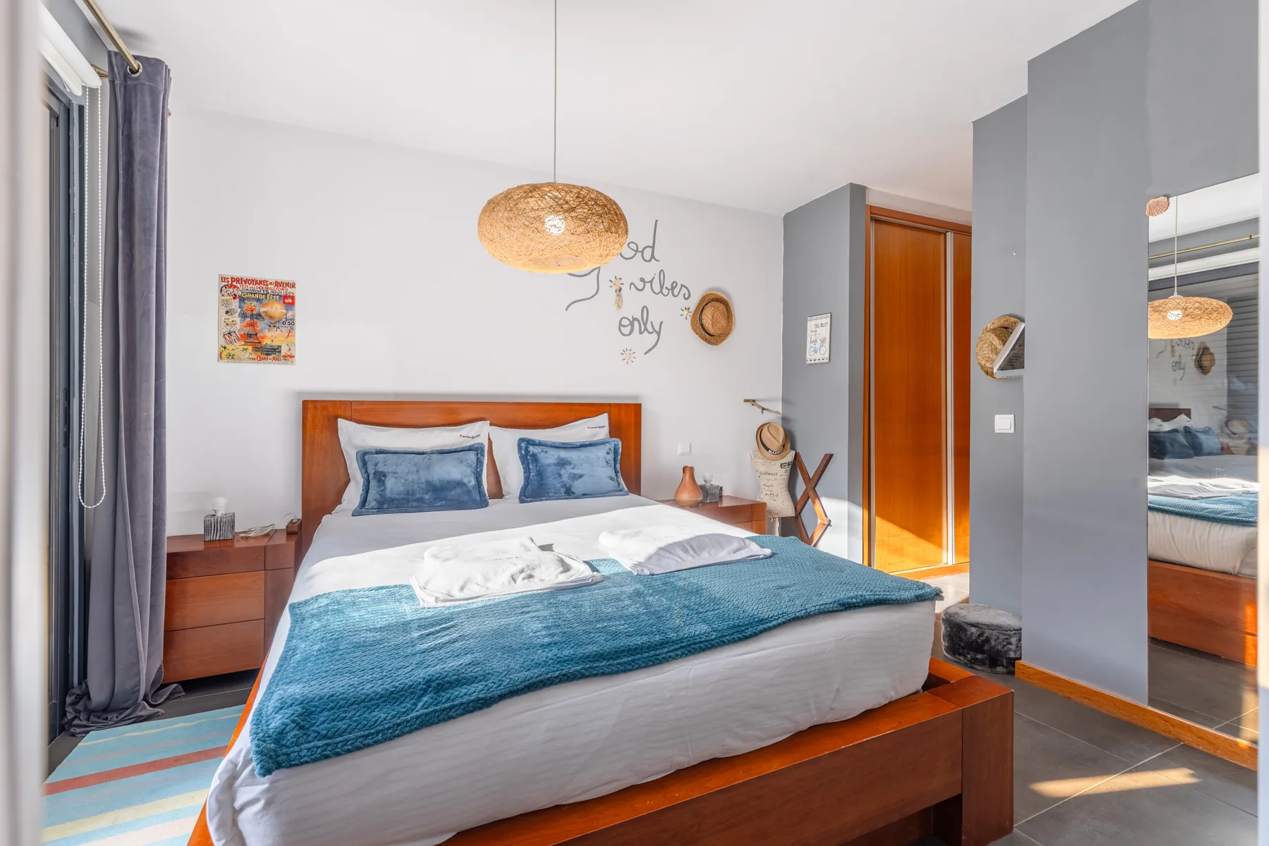 A bedroom with a bed dressed in blue and white bedding.