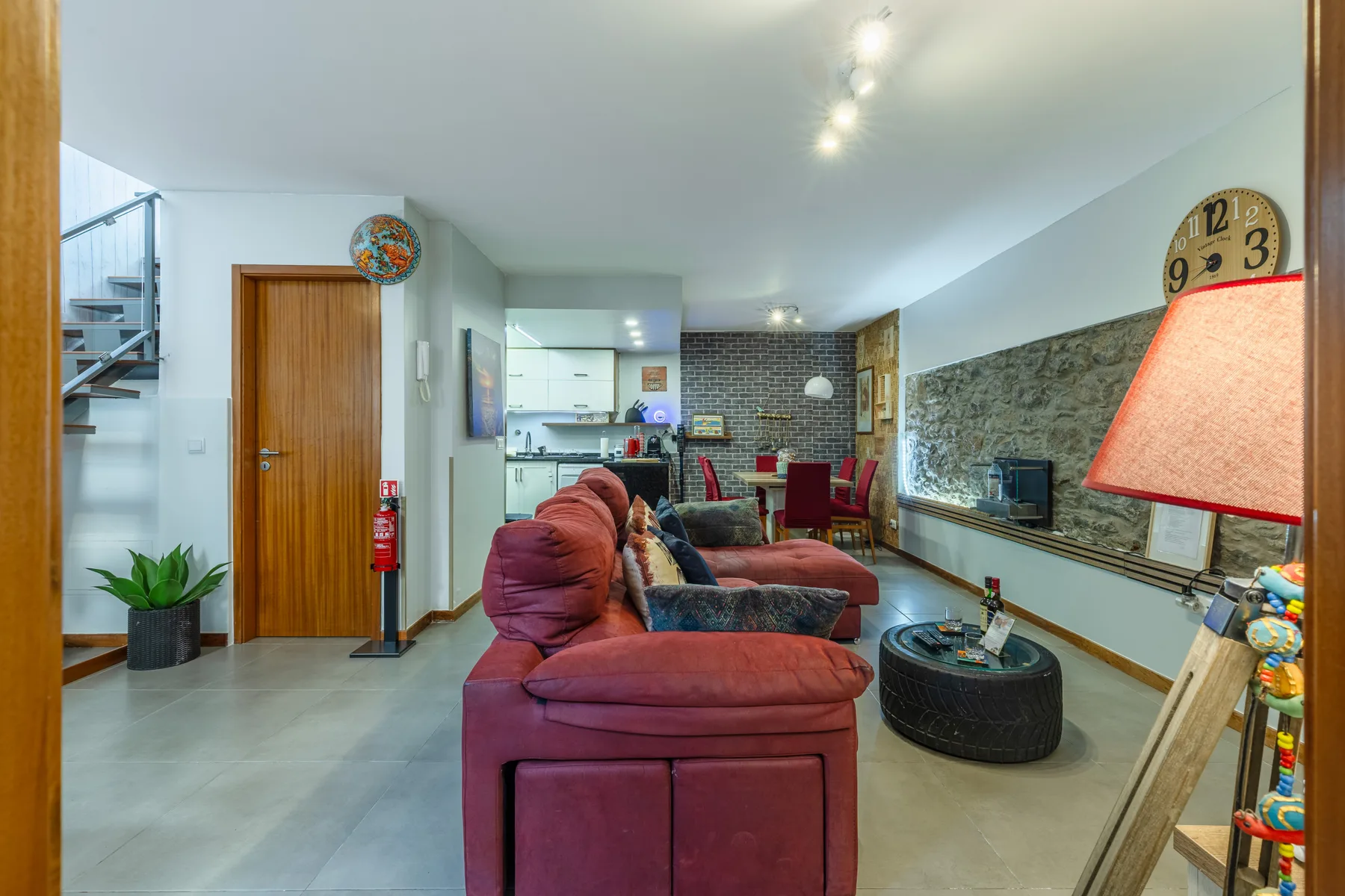 Living room with seating, a television, and an open kitchen and dining area.