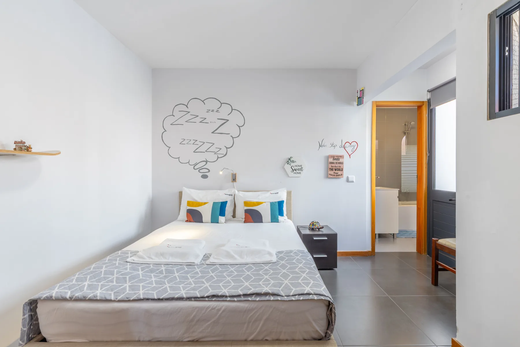 A bedroom with a double bed and a doorway opening into a bathroom.