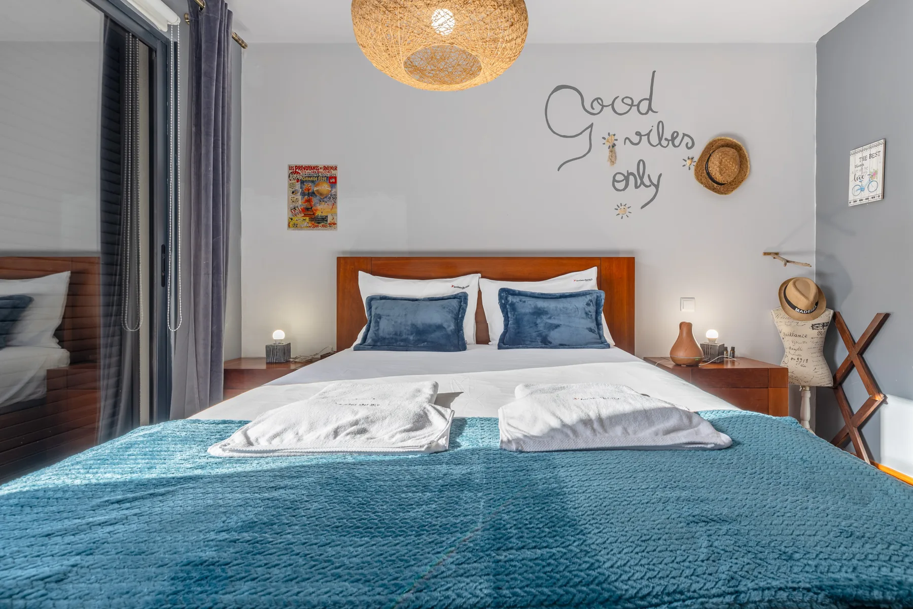 A bedroom with a neatly made bed and blue bedding.