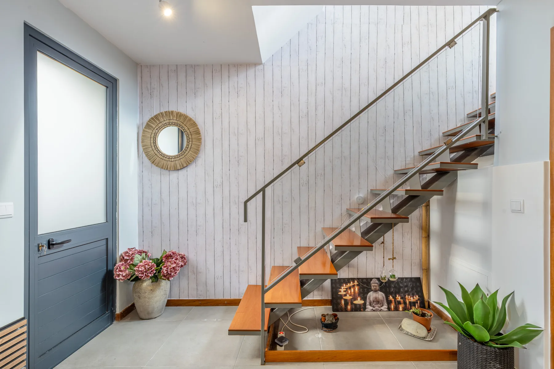 An interior entryway with a staircase and a potted plant.