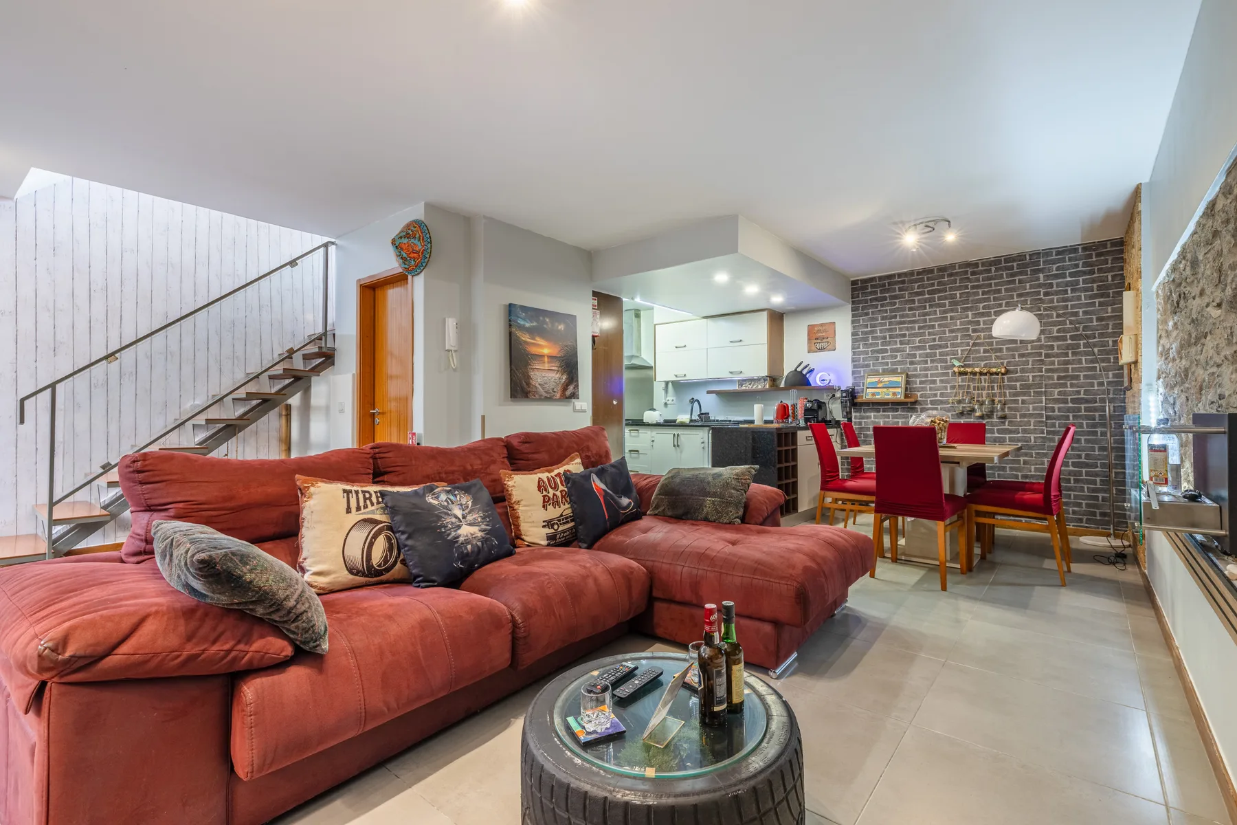 An open-plan living and dining area with red seating and a table.