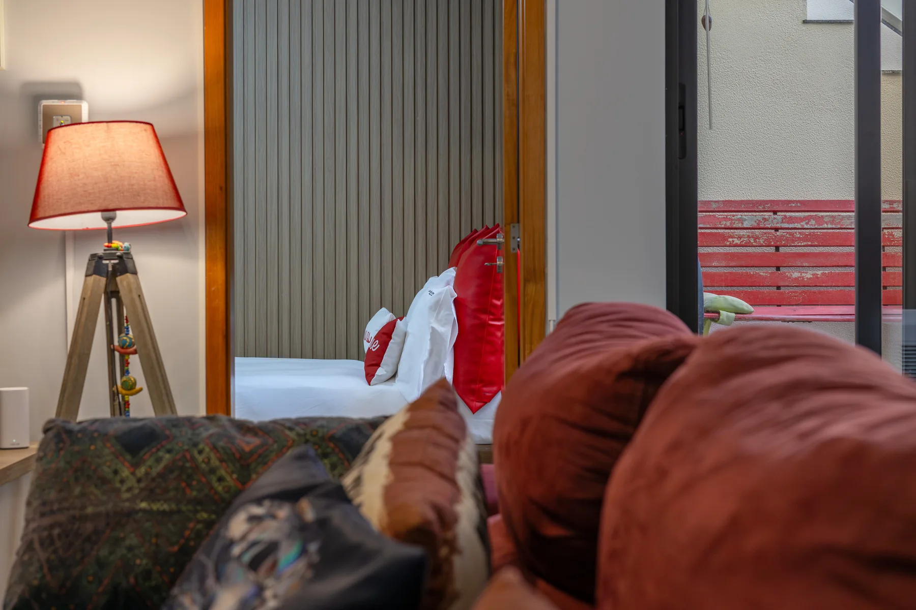 A living room with a floor lamp beside seating and a view of the balcony.