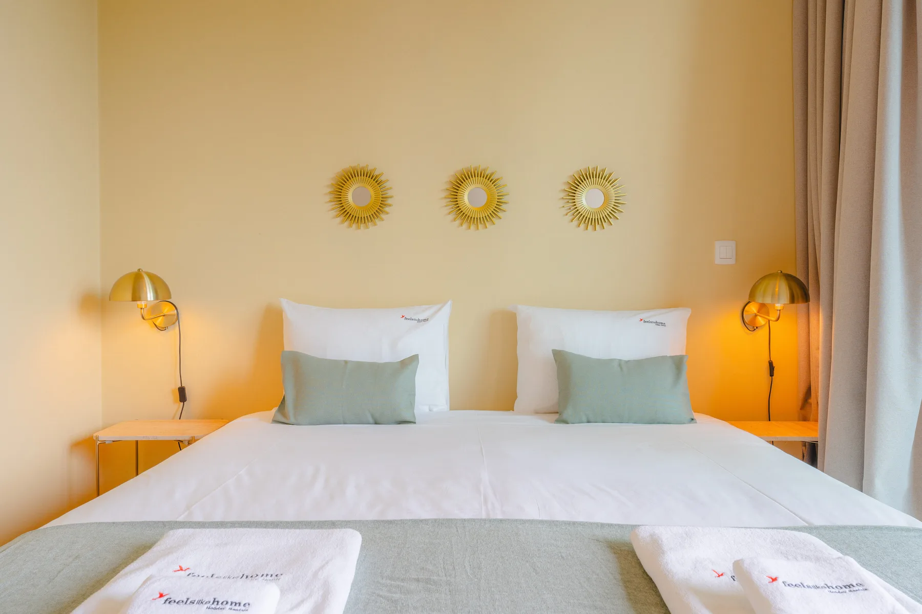Un dormitorio con una cama bien hecha y lámparas a juego junto a la cama.