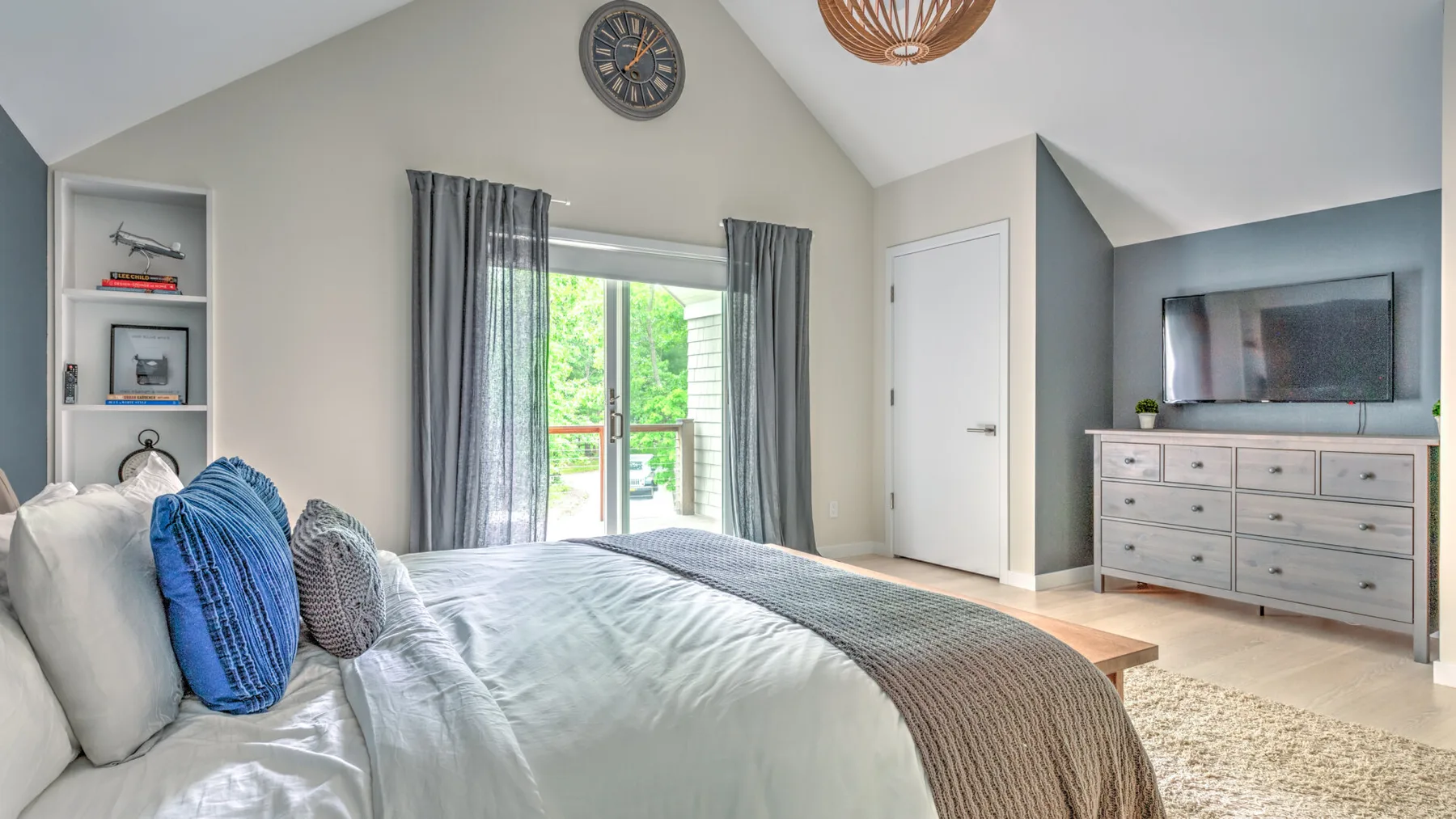 Un dormitorio luminoso con una cama junto a una ventana y una cómoda.