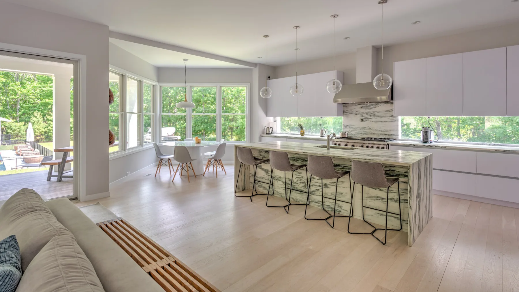 Una luminosa cocina abierta al comedor, con una isla y amplias ventanas.