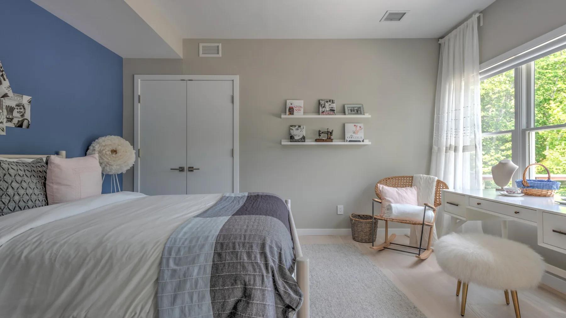 Un dormitorio con una cama, una pequeña zona de estar y una ventana amplia.