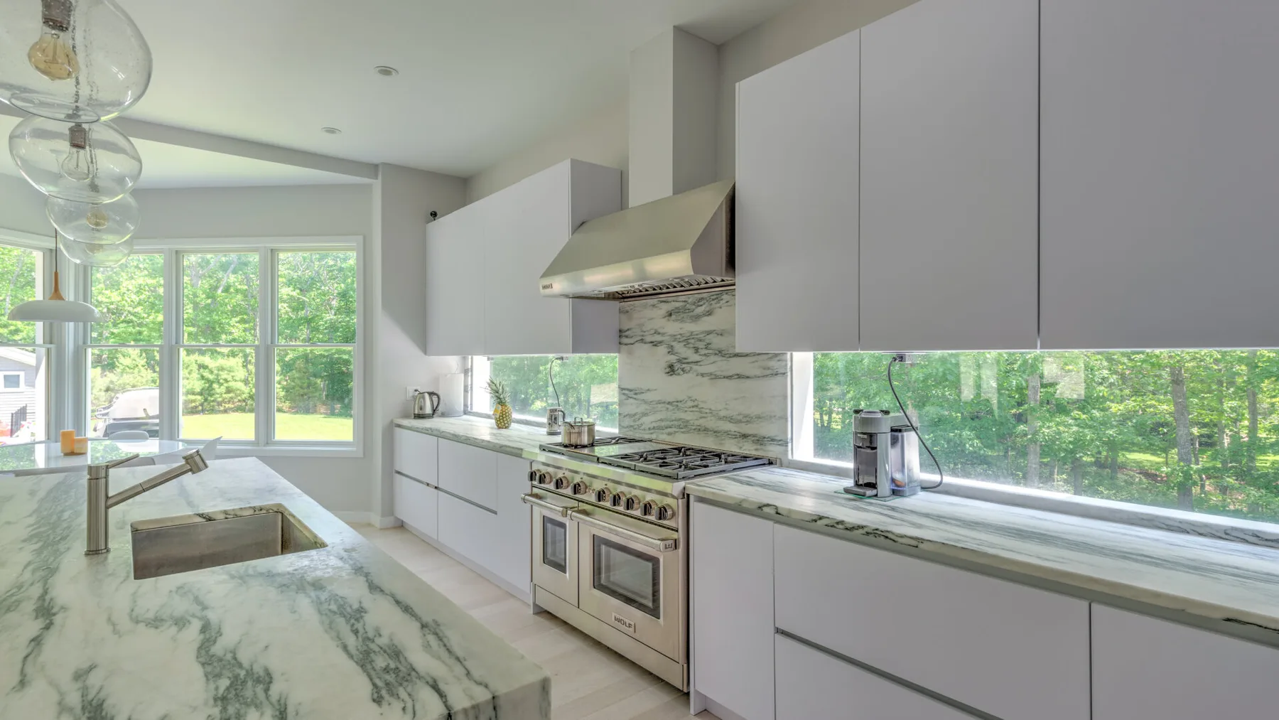 Una cocina moderna y luminosa con una gran isla y amplias ventanas.