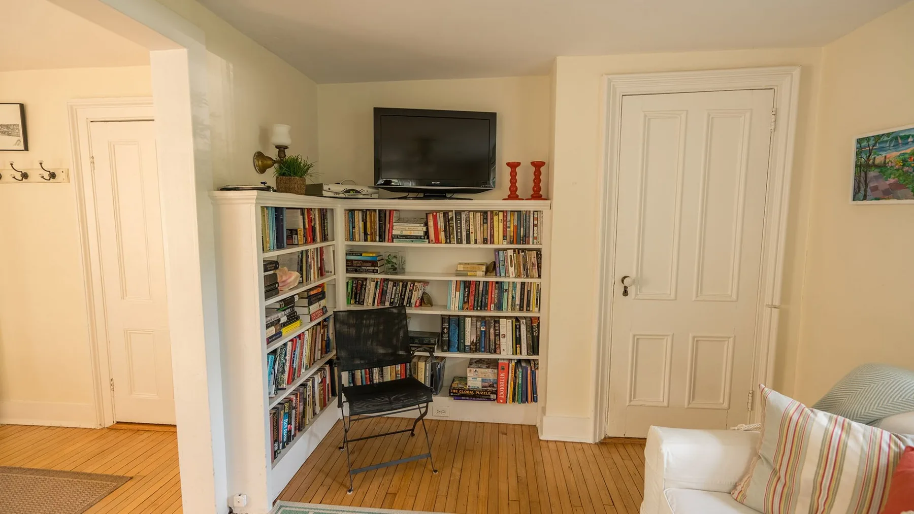 Una sala de estar con estanterías, un televisor y asientos.