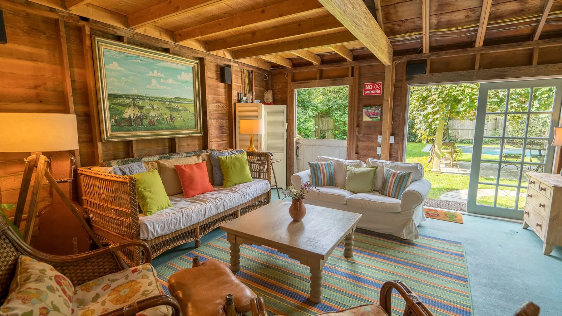 Una sala de estar rústica con asientos acolchados, una mesa de centro de madera y alfombras coloridas.