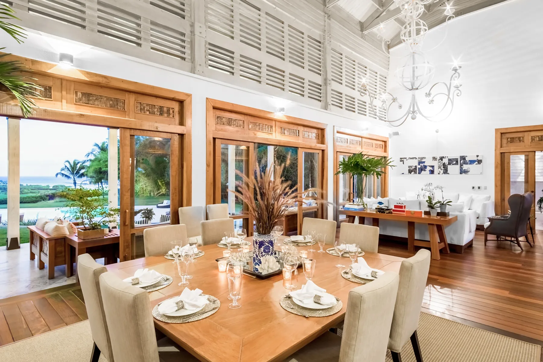 Un comedor luminoso con la mesa puesta y grandes ventanales con vistas a la vegetación.