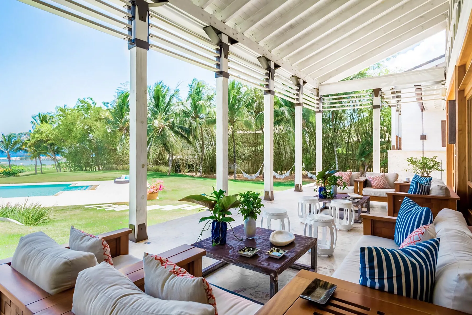 An open-air patio lounge with seating and a garden view.