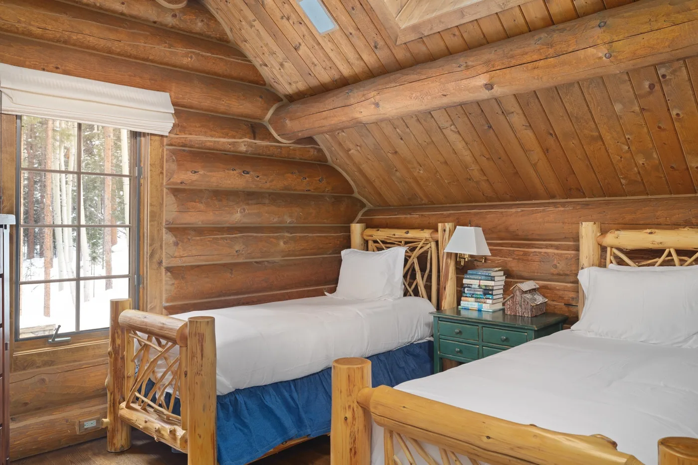 A wood-paneled bedroom with two beds and a window.