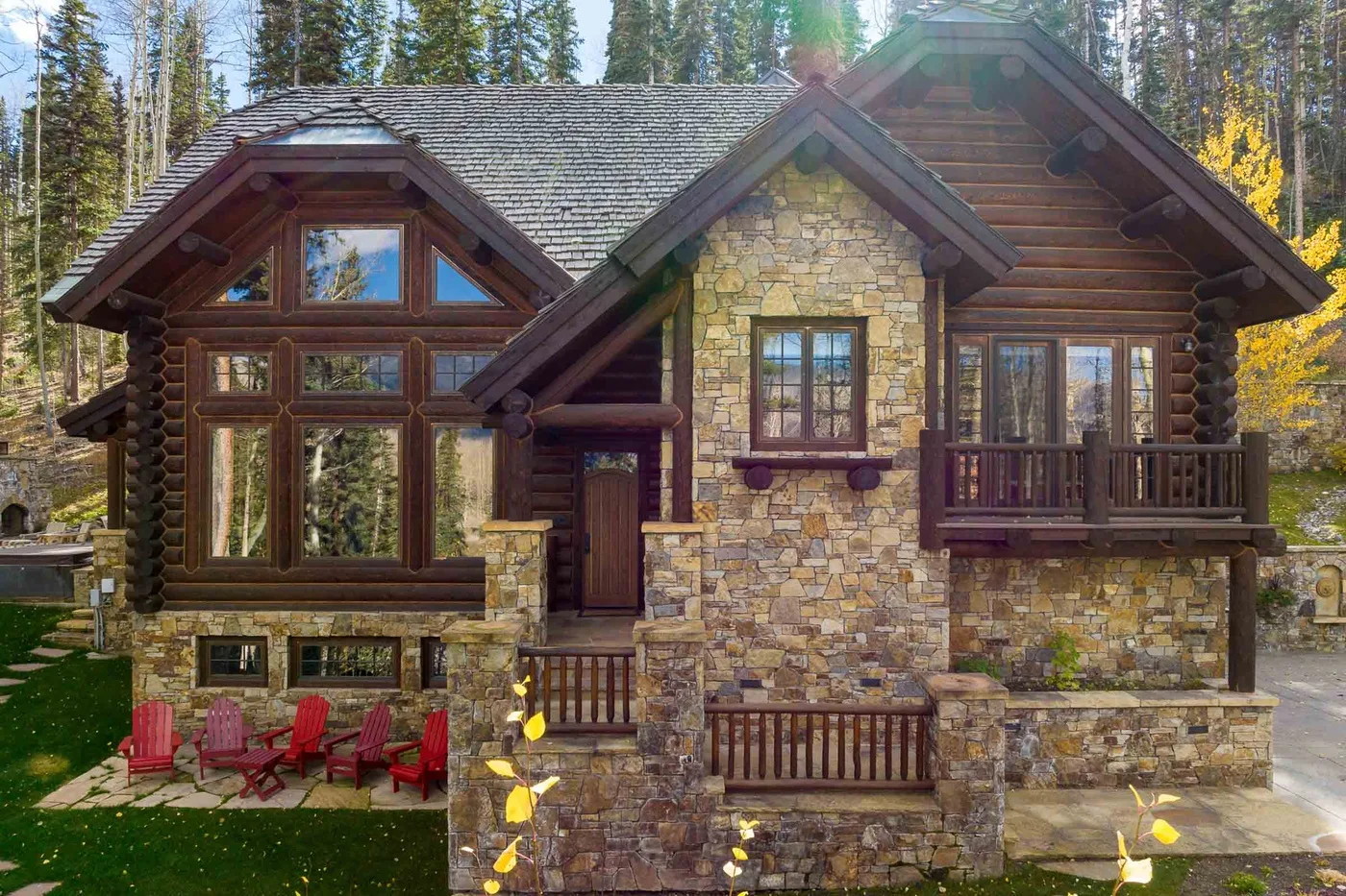 A rustic cabin exterior with stone walls, timber details, and a front porch.