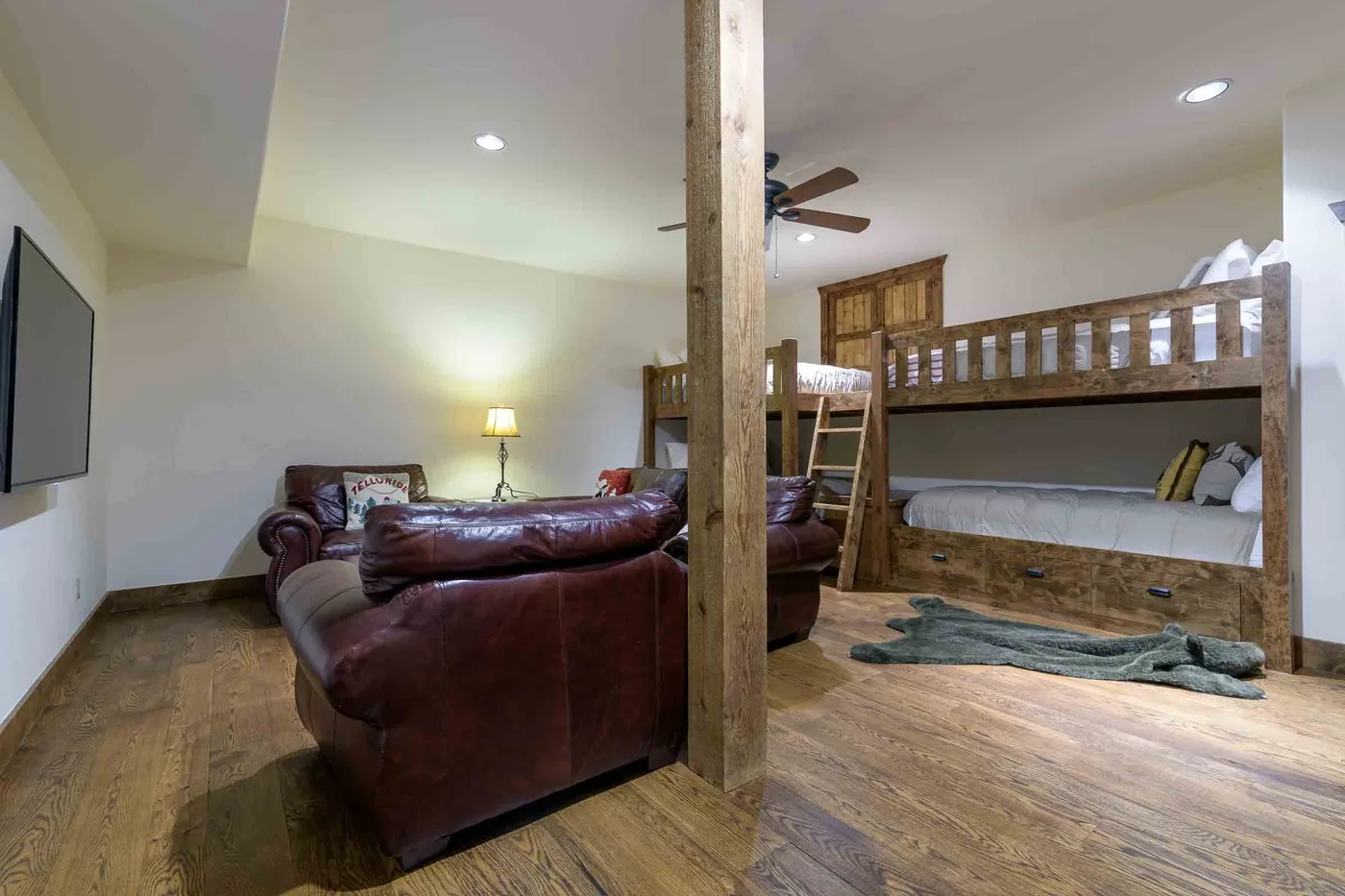 A living area with leather seating and a wooden bunk bed.