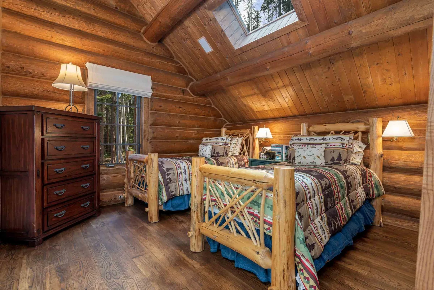 A wood-paneled bedroom with a bed beneath a sloped timber ceiling.