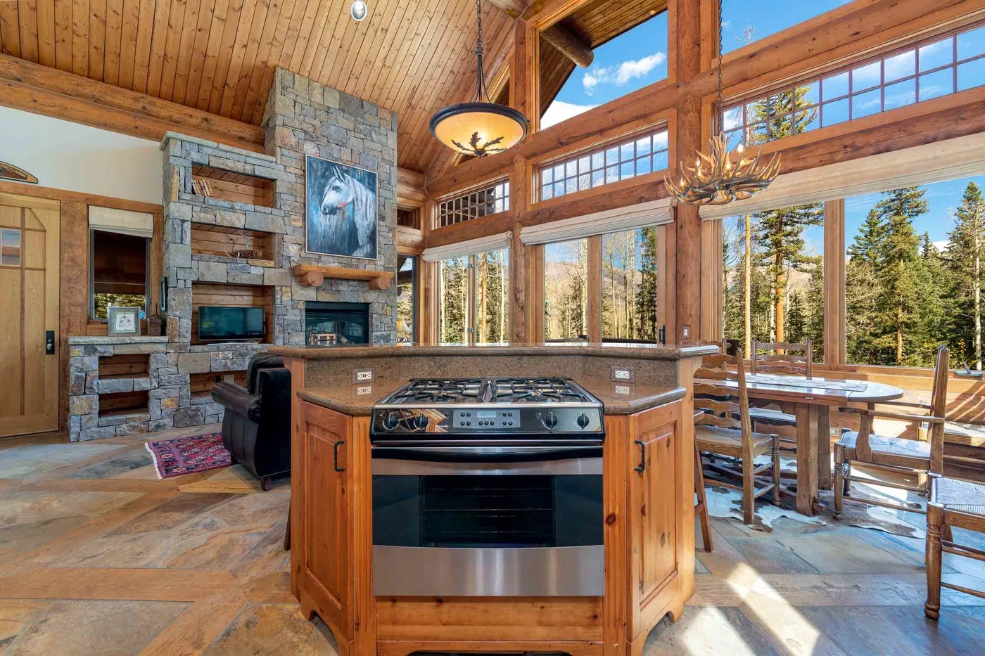 A wood-paneled kitchen with a central cooking island and large windows.