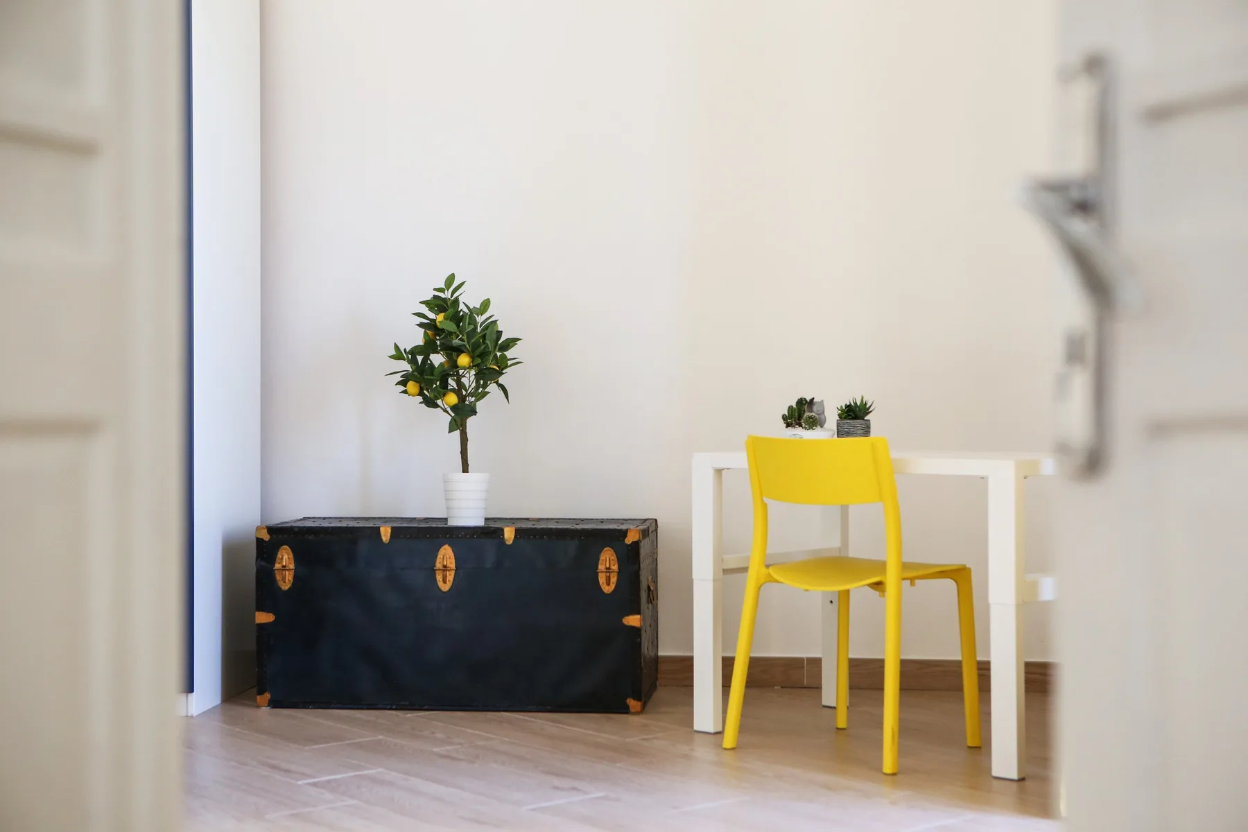 A bright room with a yellow chair beside a small white table.