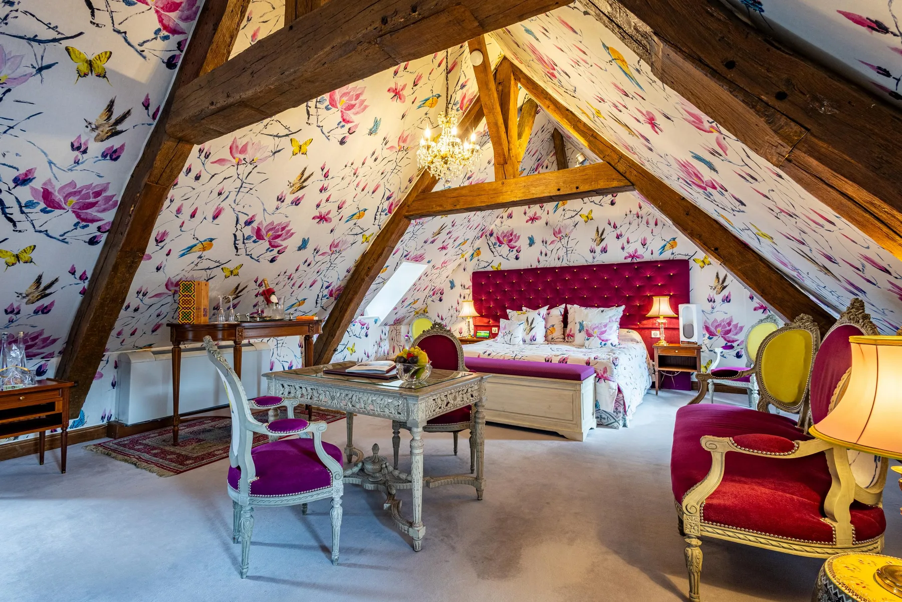 Attic guest room with floral wallpaper and a red four-poster bed