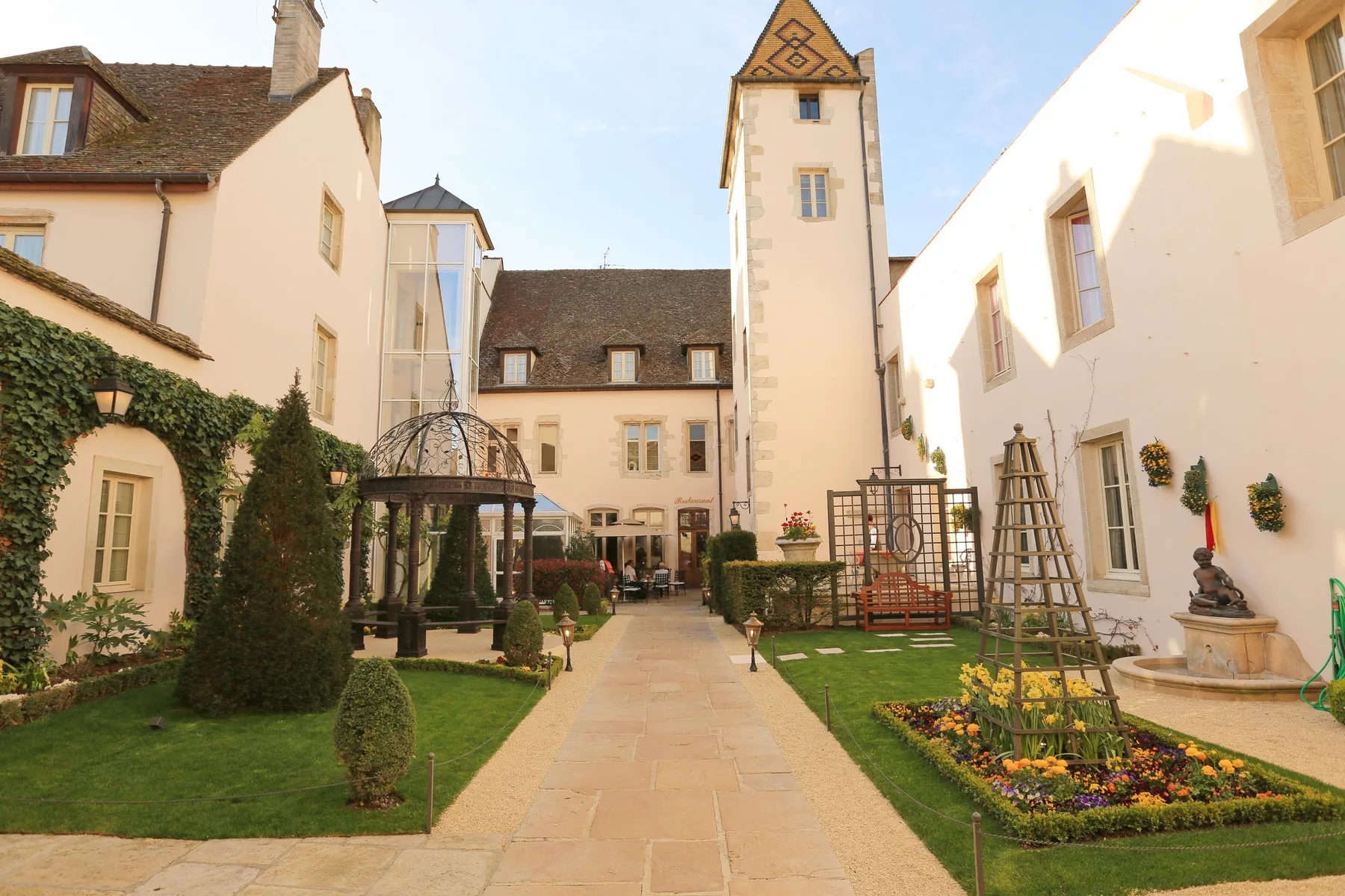 Patio de un hotel histórico con un sendero central y un jardín paisajístico