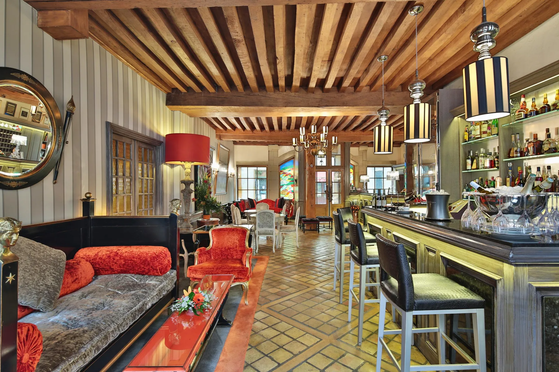 Hotel bar with counter seating, sofas and bottles on shelves