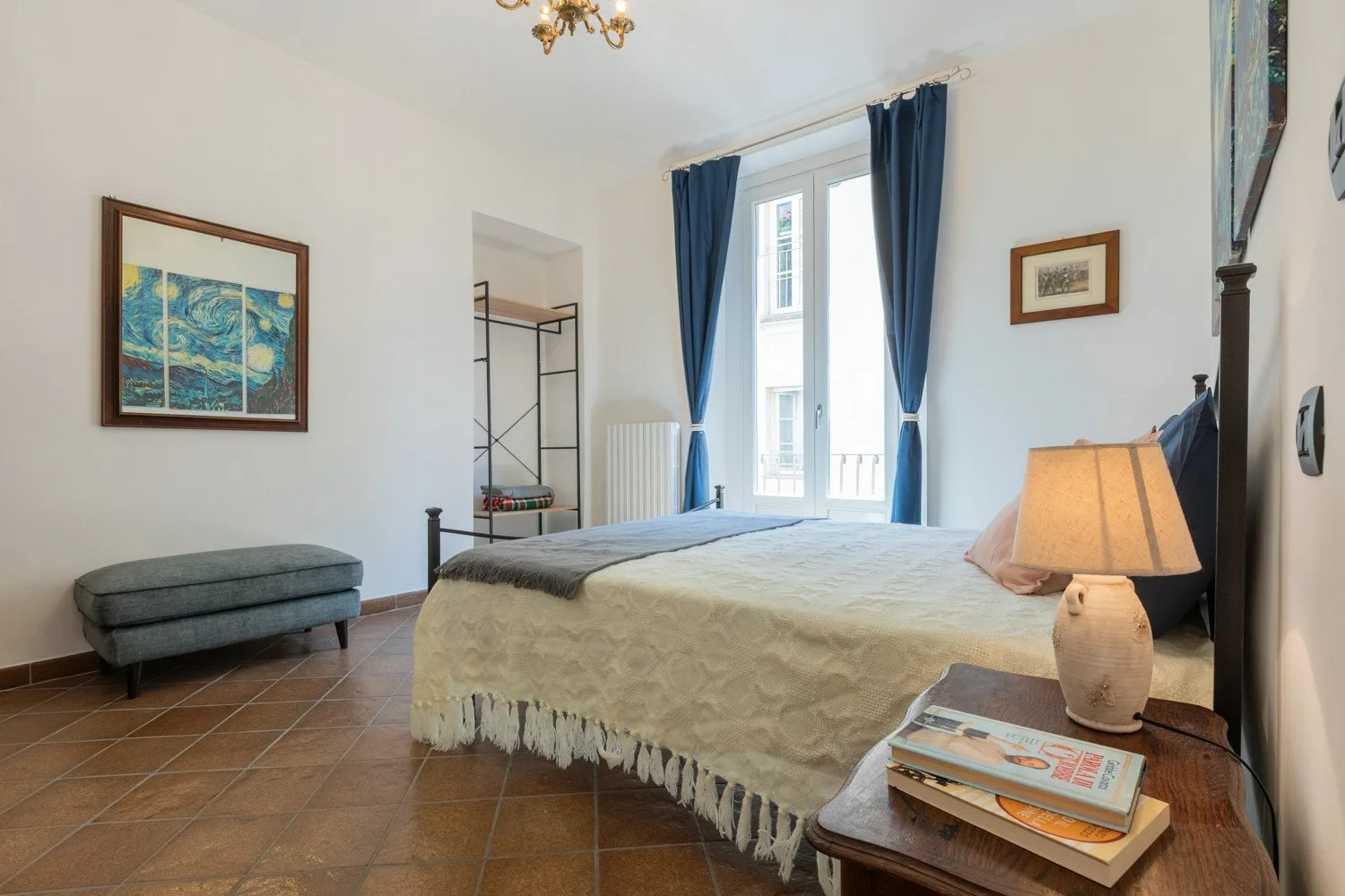Un dormitorio con una cama grande, cortinas azules y una ventana.