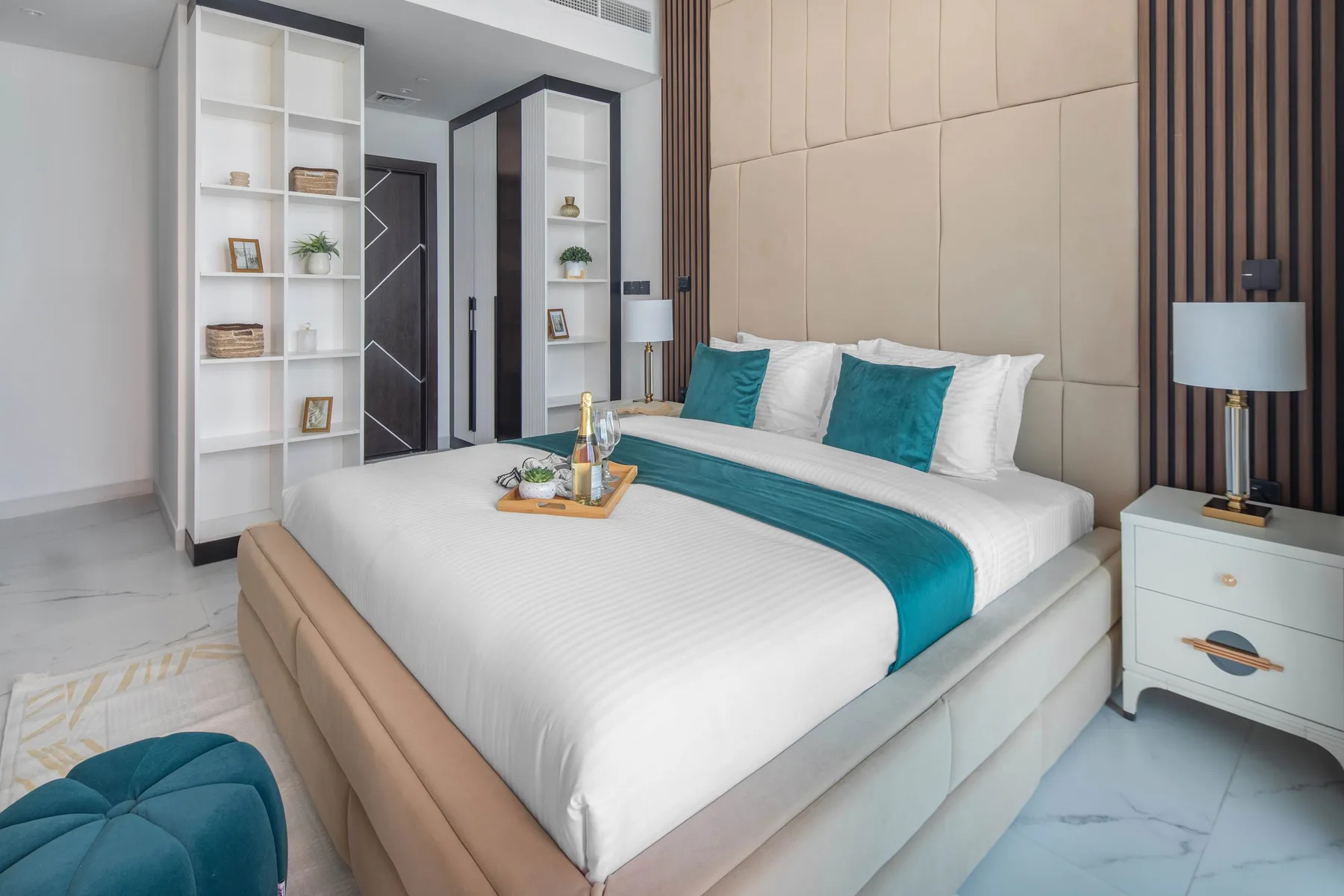 Un dormitorio con una cama tendida y detalles en tonos turquesa.