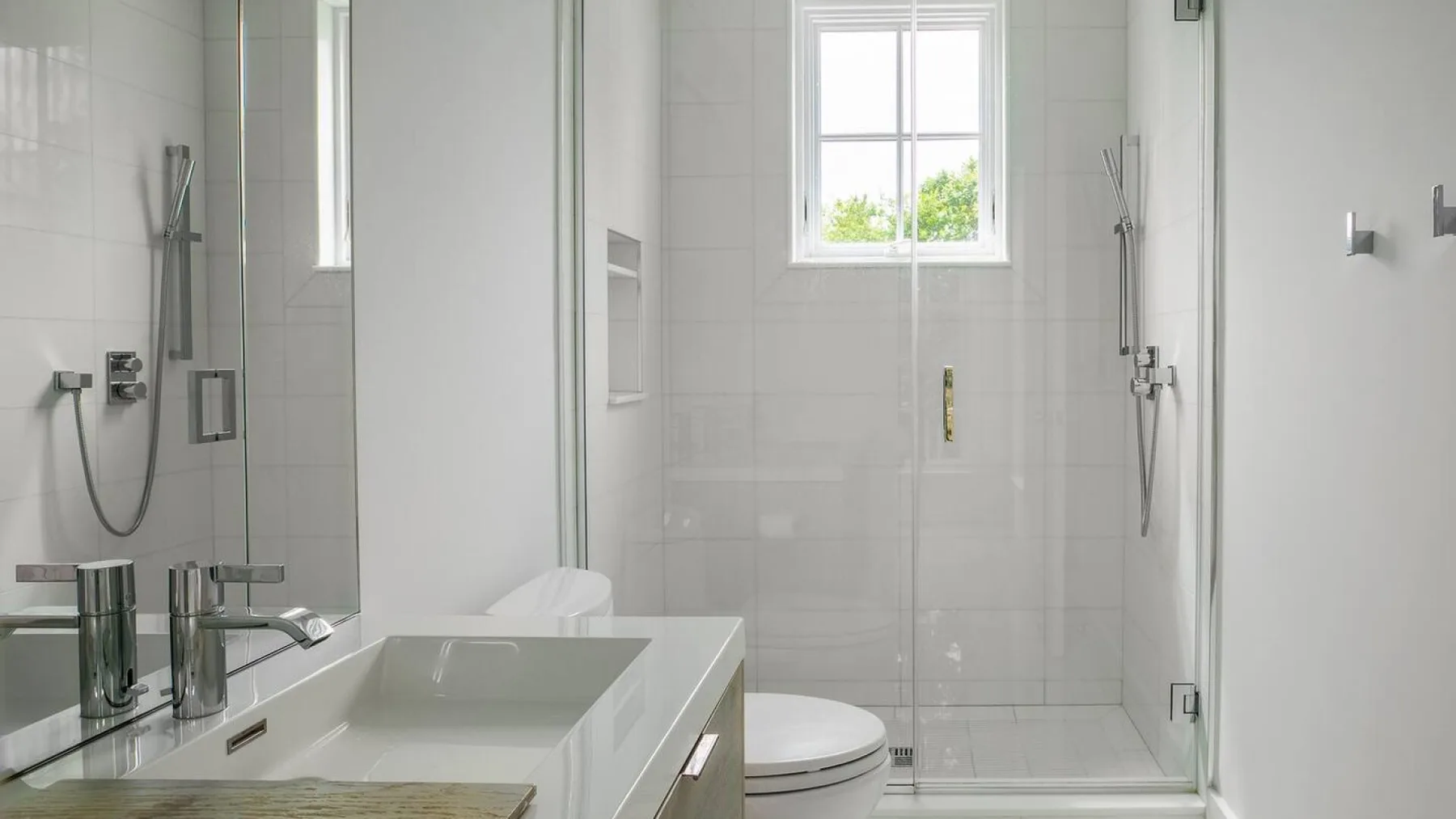 Un baño luminoso con azulejos, bañera, ducha y ventana.