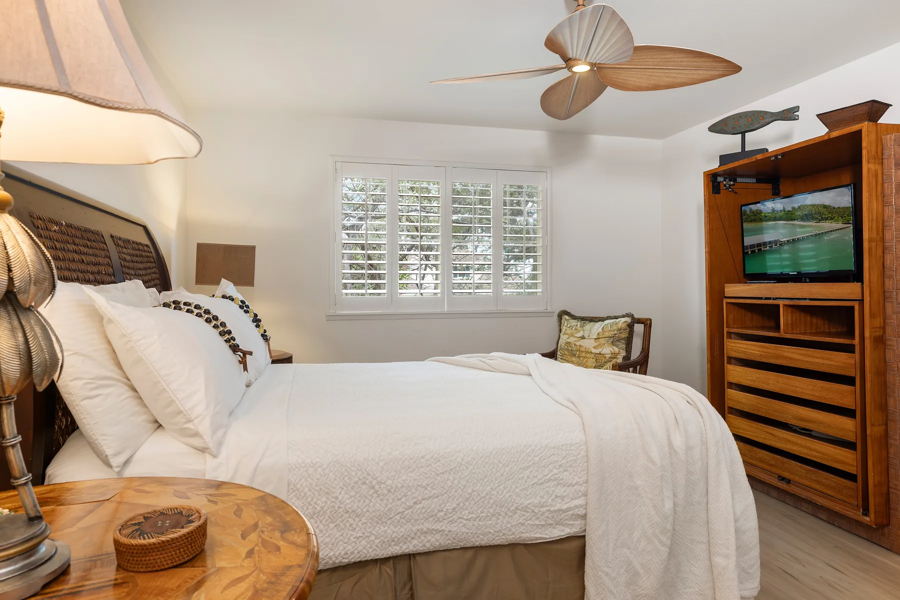 A bedroom with a neatly made bed and shuttered windows.