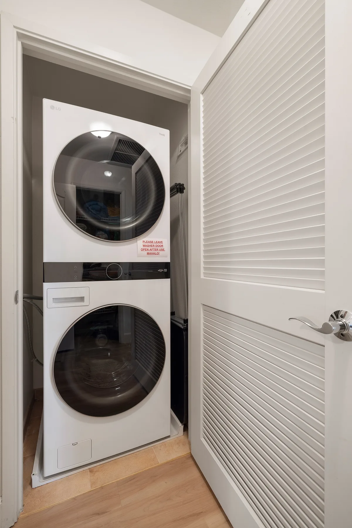 A stacked washer and dryer are visible in a small laundry closet.