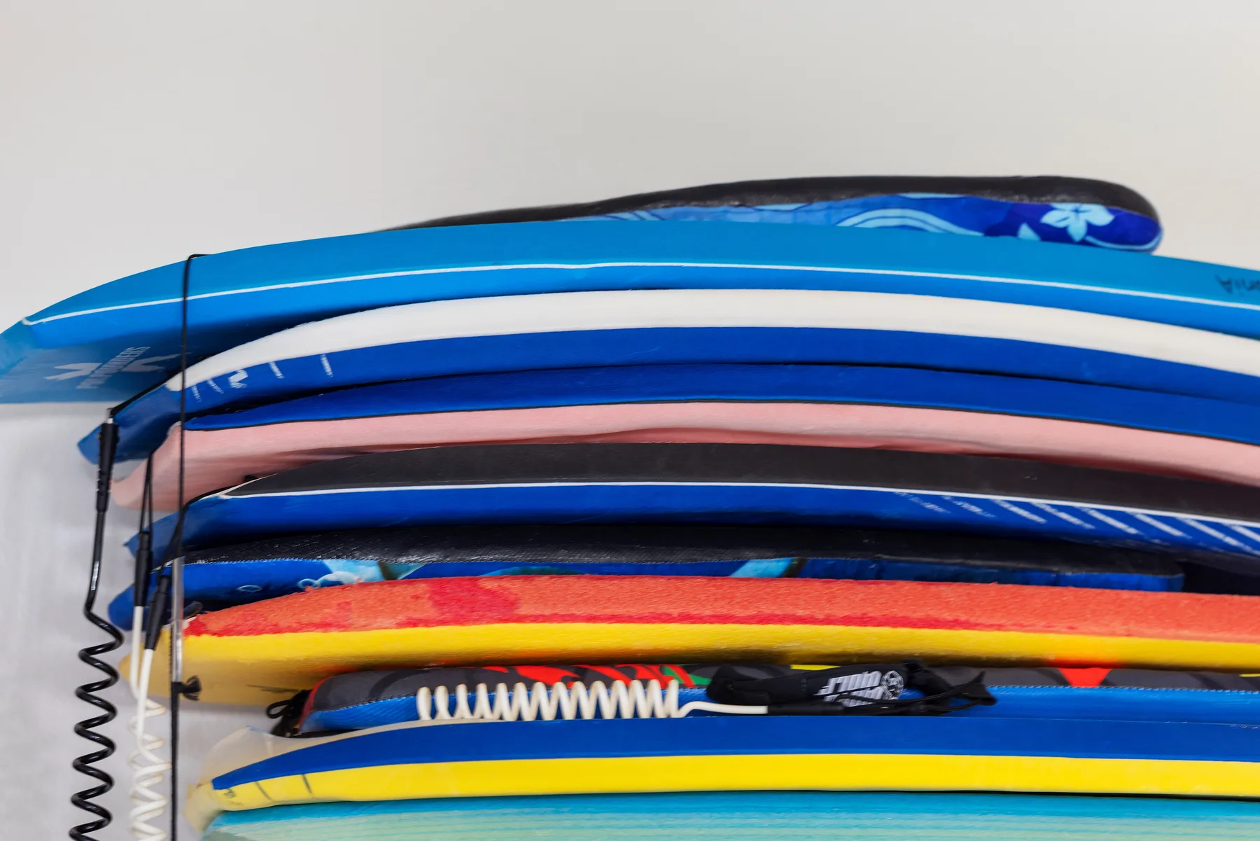 A stack of colorful boards rests on a storage rack.