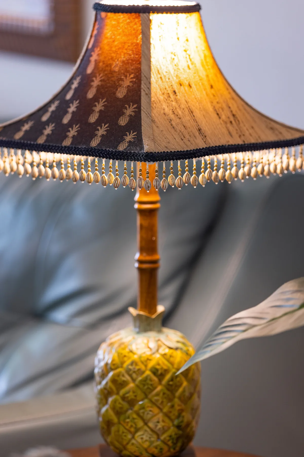 A decorative table lamp with a patterned shade and dangling fringe.