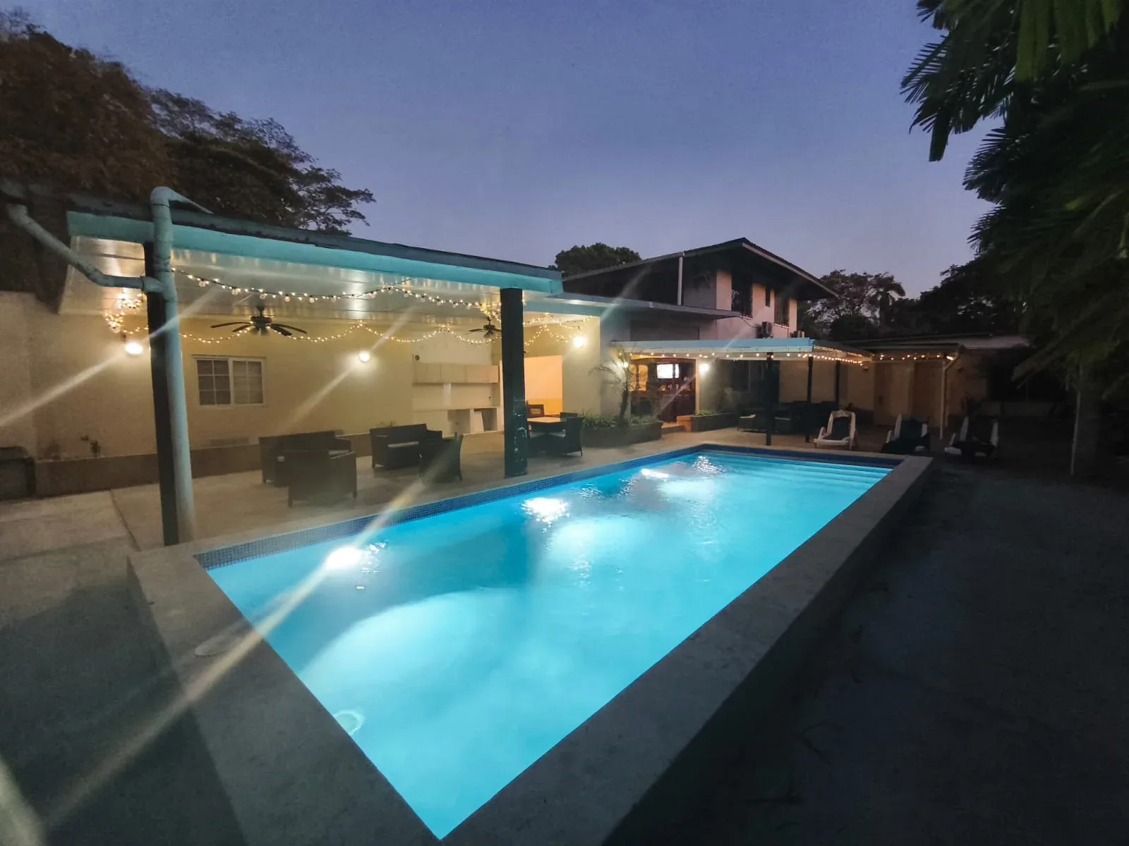 Illuminated pool and hotel exterior at dusk