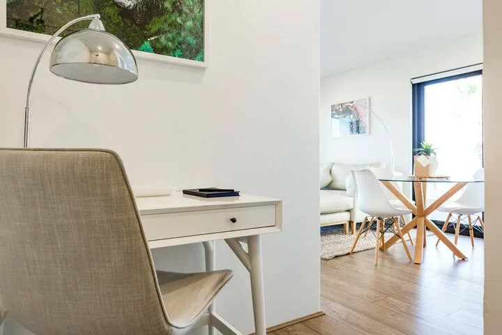 Una luminosa sala de estar y comedor con escritorio y mesa.