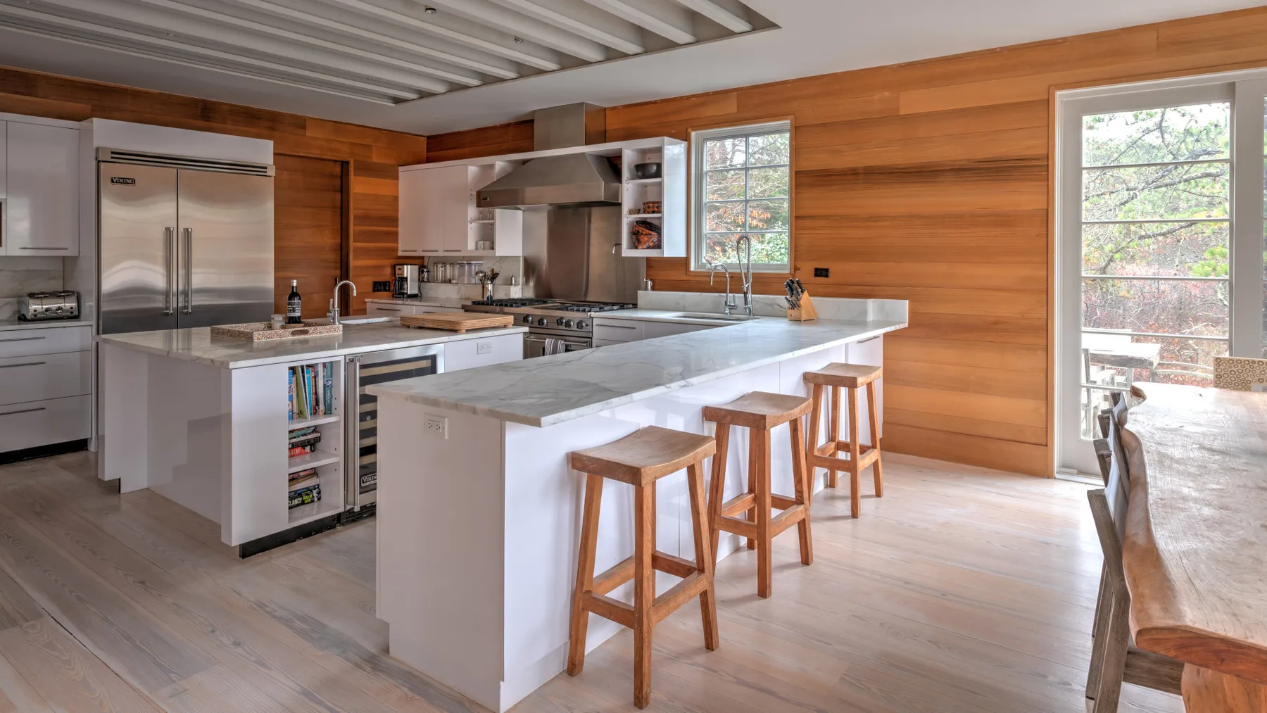 Una cocina amplia con una isla grande y taburetes de madera.