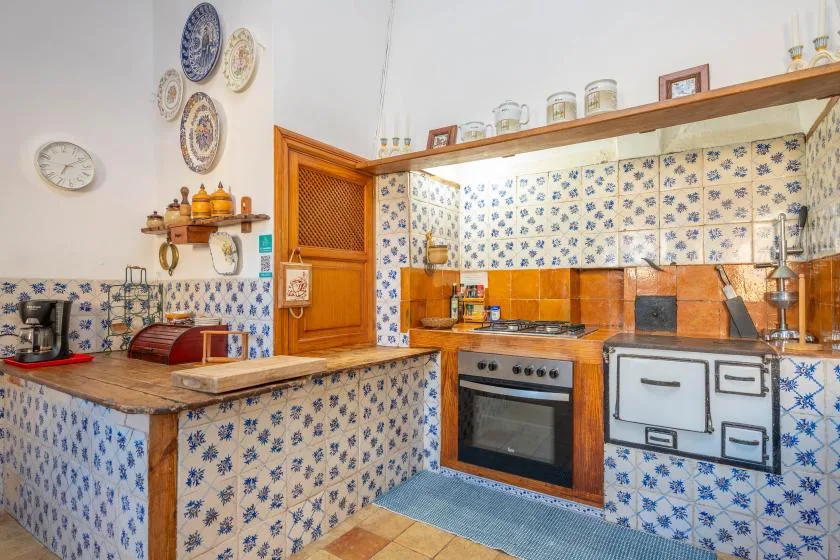 A tiled kitchen with a wooden counter and built-in oven.
