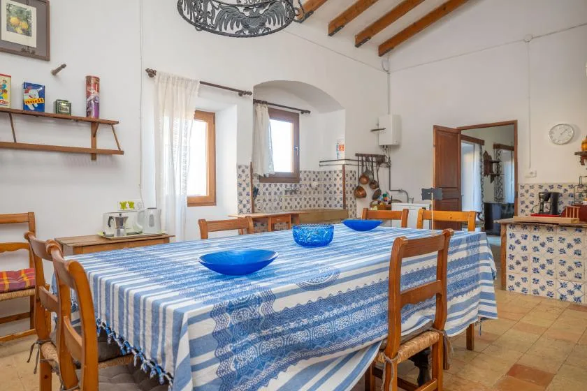 A dining room with a long table covered in a blue-and-white striped cloth.