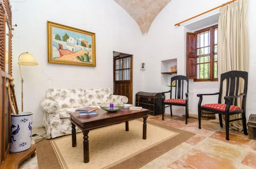 A sitting room with patterned seating, a coffee table, and a window.