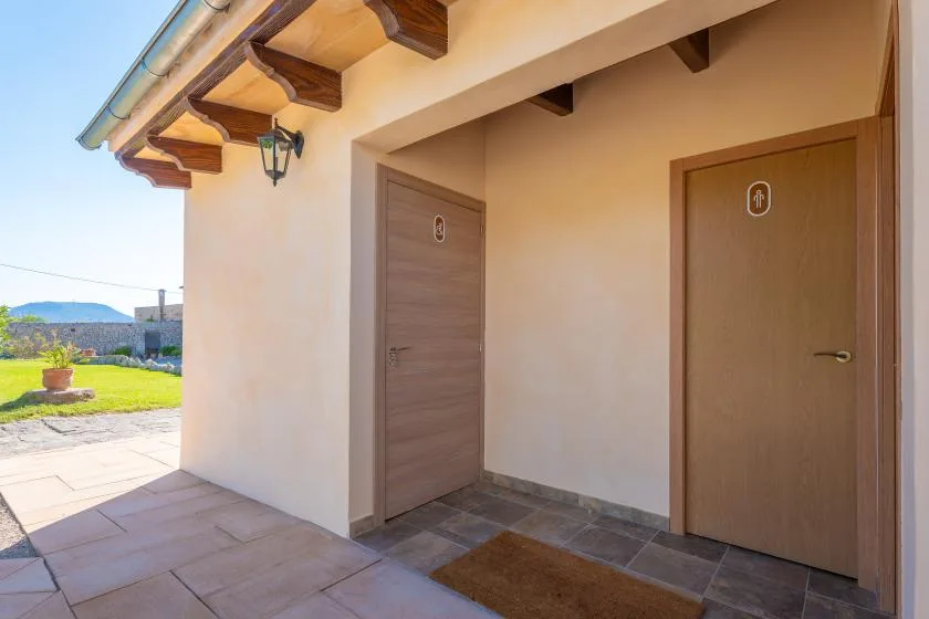 An outdoor entrance area with two doors beneath a covered eave.