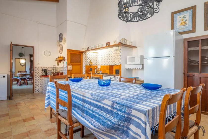 A dining room with a long table covered in a blue-and-white patterned cloth.