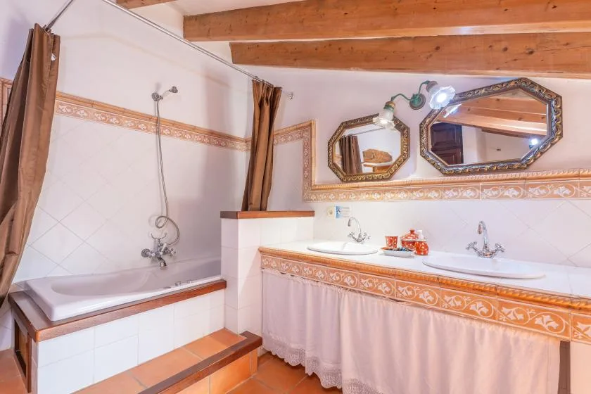 A tiled bathroom with a bathtub, shower, and long vanity.