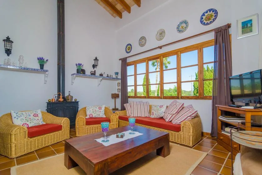 A living room with wicker seating arranged around a wooden coffee table.