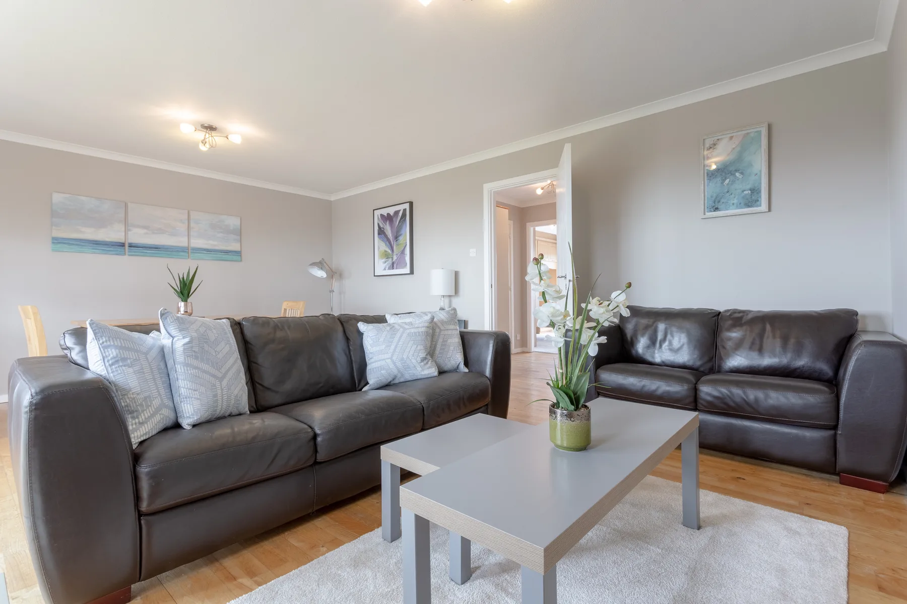 A living room with dark seating arranged around a coffee table.