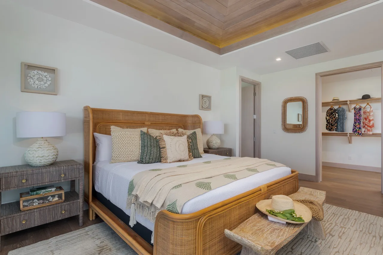 A bedroom with a woven bed, bedside tables, and an open closet.